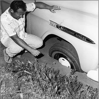 Photograph of truck stuck in pothole.